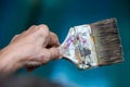 Senior woman left hand holding old paintbrush in bokeh blue swimming pool background, Selective focus, Hobby paint art concept Royalty Free Stock Photo