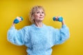 Strong Sportive Elderly Woman Lifting Dumbbells Up Isolated On Yellow Background Royalty Free Stock Photo