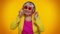 Senior woman listening music on headphones dancing disco fooling, having fun, gesticulating hands