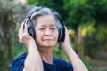 Senior woman listening music from wireless headphone Royalty Free Stock Photo