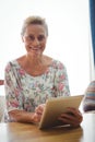 Senior woman looking at the camera using a digital tablet Royalty Free Stock Photo