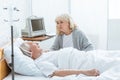 Senior woman looking at ill husbend in hospital