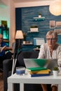 Senior woman looking at laptop on couch at home Royalty Free Stock Photo