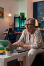 Senior woman looking at laptop on sofa at home Royalty Free Stock Photo