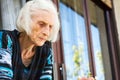 Senior woman looking out of home window Royalty Free Stock Photo