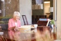 Senior Woman Looking At Photo Album Through Window Royalty Free Stock Photo