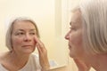 Senior woman looking wrinkles mirror Royalty Free Stock Photo