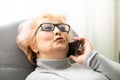 Senior woman lying on bed making phone call in bedroom at home. Portrait beautiful of smiling mature female talking on Royalty Free Stock Photo