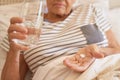 Senior woman lying in bed taking medicine in the morning Royalty Free Stock Photo