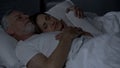 Senior woman lying on male chest, couple sleeping in bed, man hugging her Royalty Free Stock Photo