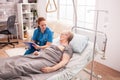 Senior woman lying in nursing home bed Royalty Free Stock Photo