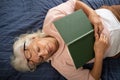 senior woman lying on sofa and sleeping with book Royalty Free Stock Photo