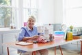 Senior Woman Making Clothes Using Sewing Machine At Home Royalty Free Stock Photo