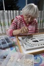 Senior woman making a necklace