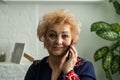 Senior woman making phone call in bedroom at home. Portrait beautiful of smiling mature female talking on smartphone Royalty Free Stock Photo