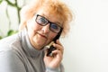 Senior woman making phone call at home. Portrait beautiful of smiling mature female talking on smartphone, relaxing Royalty Free Stock Photo