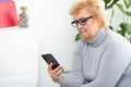 Senior woman making phone call at home. Portrait beautiful of smiling mature female talking on smartphone, relaxing Royalty Free Stock Photo