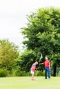 Senior woman and man playing golf putting on green Royalty Free Stock Photo