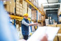 Senior woman manager and man worker working in a warehouse. Royalty Free Stock Photo