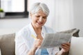Senior woman marking newspaper ad at home