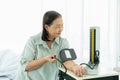 Senior woman measures blood pressure on her left hand with a digital blood pressure monitor Royalty Free Stock Photo