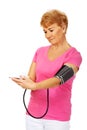 Senior woman measuring blood pressure with automatic manometer Royalty Free Stock Photo