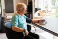 Senior woman measuring blood pressure at home