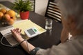 Senior woman measuring blood pressure, showing very high values