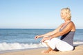 Senior Woman Meditating On Beach Royalty Free Stock Photo