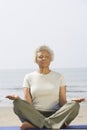 Senior Woman Meditating At Beach Royalty Free Stock Photo