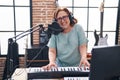 Senior woman musician singing song playing piano keyboard at music studio Royalty Free Stock Photo