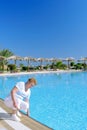 Senior woman near water pool, touch a water. Royalty Free Stock Photo