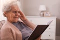 Senior woman with notebook at home. Age-related memory impairment