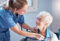 Senior woman, nurse and stethoscope to check heartbeat, breathing and health of and elderly patient during nursing home Royalty Free Stock Photo