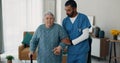 Senior woman, nurse and walking stick for support at nursing home in retirement. Elderly female patient with disability Royalty Free Stock Photo