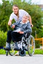 Senior woman in nursing home with nurse in garden Royalty Free Stock Photo