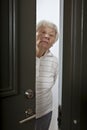 Senior woman opening front door