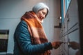 Senior woman opens the mailbox to check for new mails Royalty Free Stock Photo