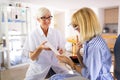 Senior woman optometrist examining patient in modern ophthalmology clinic