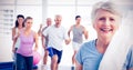 Senior woman with people exercising in fitness studio