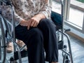 Senior woman person sits in wheelchair on the floor while caregiver, assistant take a walk inside the building at home.