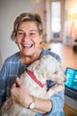 Senior woman with pet dog and laptop working in home office. Royalty Free Stock Photo