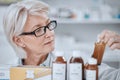 Senior woman, pharmacist and inventory inspection, medicine or checking stock on shelf at drugstore. Mature female Royalty Free Stock Photo