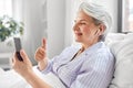 senior woman with phone having video call in bed Royalty Free Stock Photo