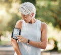 Senior woman with phone running app for steps, fitness and training exercise tracking while on run, walk or cardio Royalty Free Stock Photo