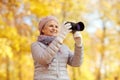 Senior woman with photo camera at autumn park Royalty Free Stock Photo