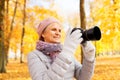 Senior woman with photo camera at autumn park Royalty Free Stock Photo