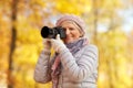 Senior woman with photo camera at autumn park Royalty Free Stock Photo