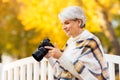 Senior woman with photo camera at autumn park Royalty Free Stock Photo