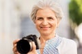 Senior woman photographing by digital camera